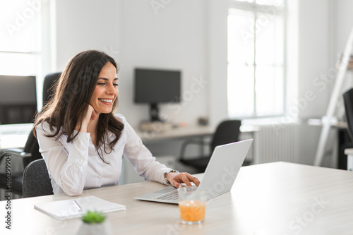 Businesswoman working on laptop in sharred office space