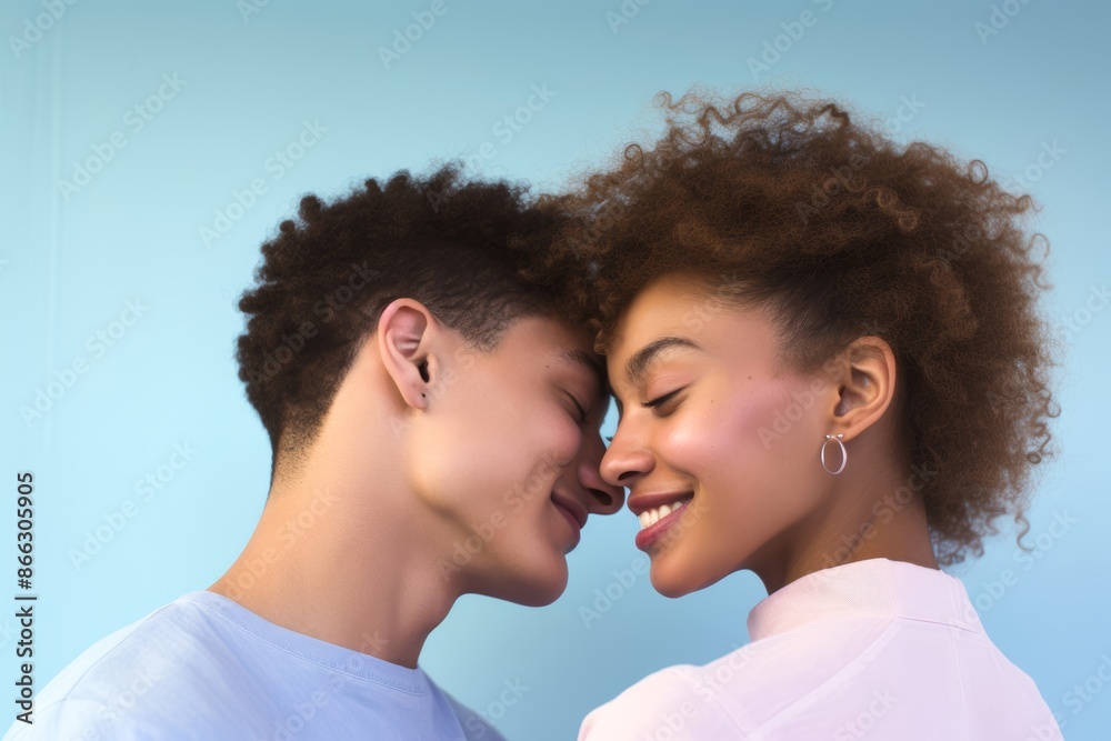 Couple, age 18, African American, sharing a tender moment, first love, pastel blue background Couple, age 18, African American, sharing a tender moment, first love, pastel blue background