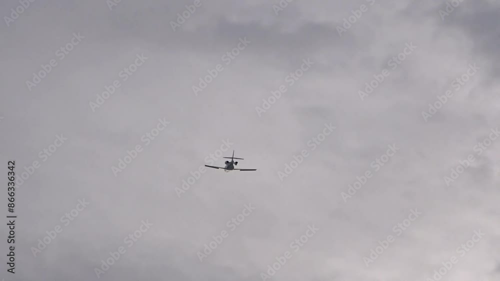 Airplane small jet aircraft taking off from airport silhouette generic grey clouds belly view