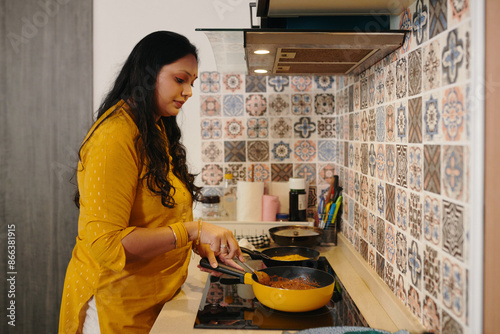 Indian woman cooking dinner for her family in the kitchen