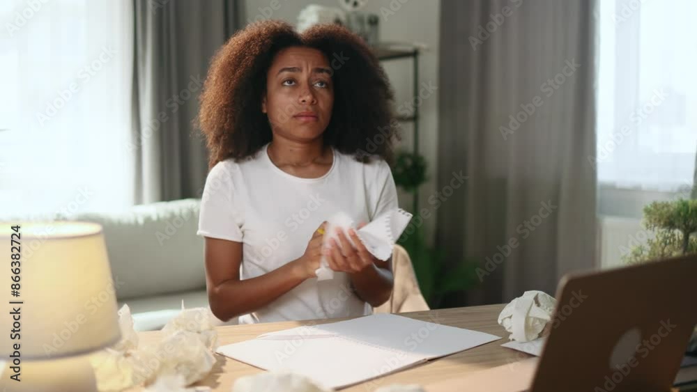 Sad young curly woman student or freelancer with lack of new ideas or creative block writing and crossed out at home workplace Worried female with failed ideas looking at camera indoors Sad young curly woman student or freelancer with lack of new ideas or creative block writing and crossed out at home workplace Worried female with failed ideas looking at camera indoors