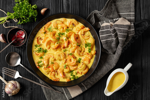 Fotografie Sauteed Shrimp in creamy saffron sauce, top view