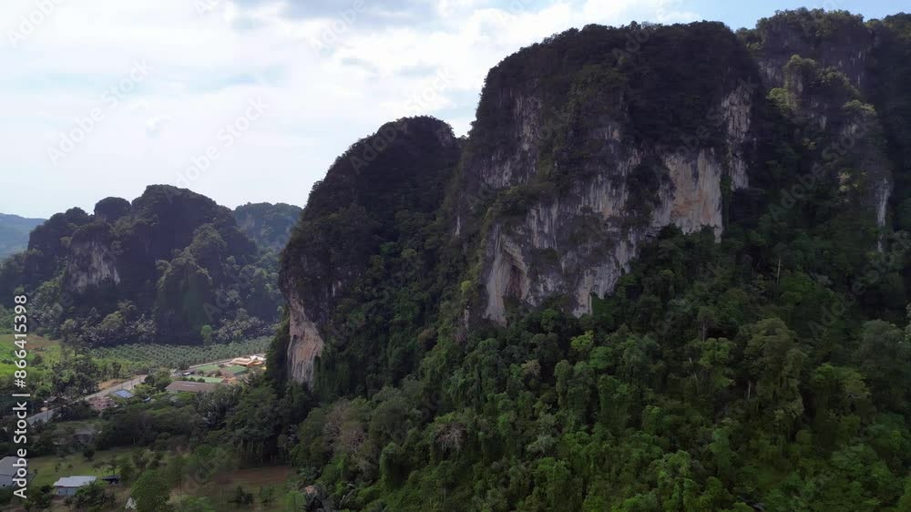 Lush green forest is covering the valley floor below towering limestone mountains in krabi, thailand. Stunning aerial view flight rotation to right drone Lush green forest is covering the valley floor below towering limestone mountains in krabi, thailand. Stunning aerial view flight rotation to right drone