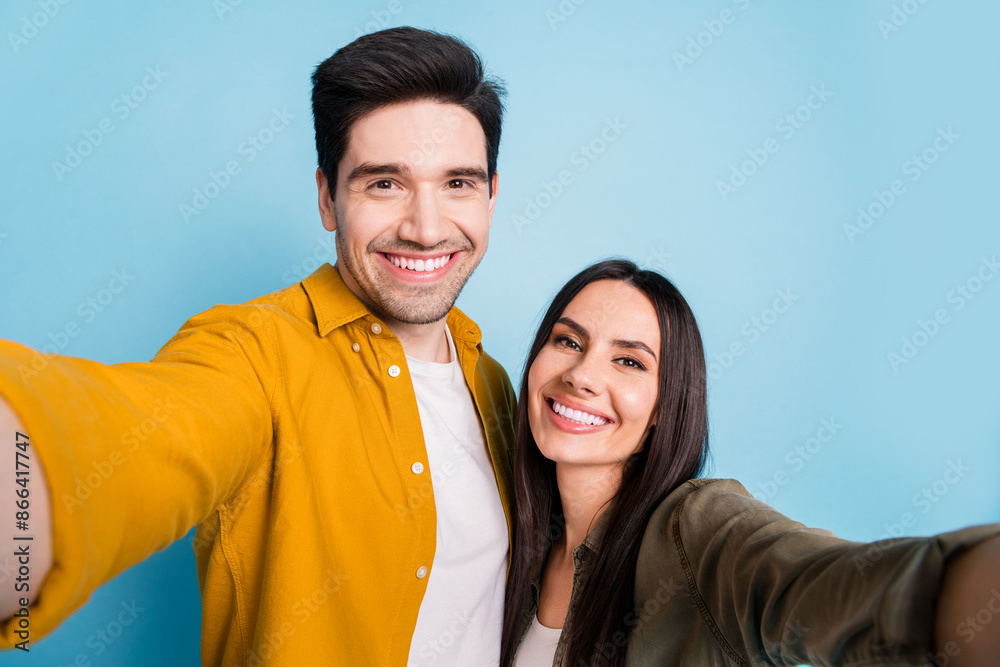 Portrait of two young people take selfie wear shirt isolated on blue color background Portrait of two young people take selfie wear shirt isolated on blue color background