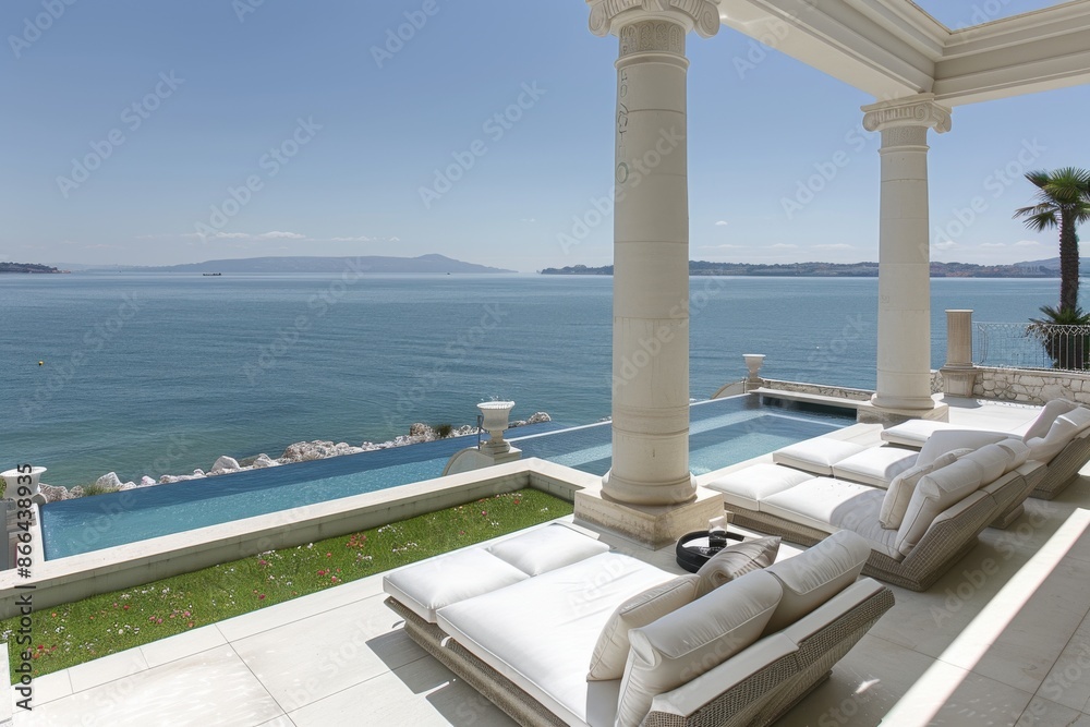 Fototapeta premium Luxurious seaside terrace with white furniture and ocean view featuring a serene and upscale outdoor setting perfect for relaxation and enjoying the coastal scenery