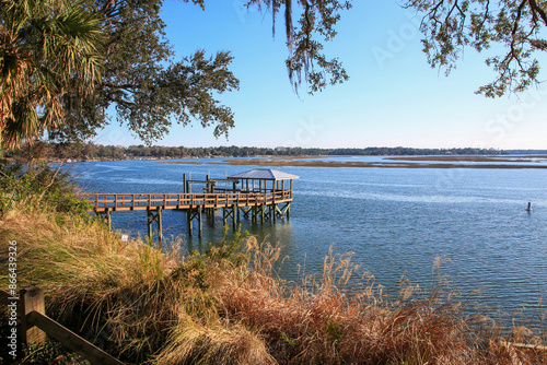 A wooden dock in Bluffton South Carolina extends over calm blue water