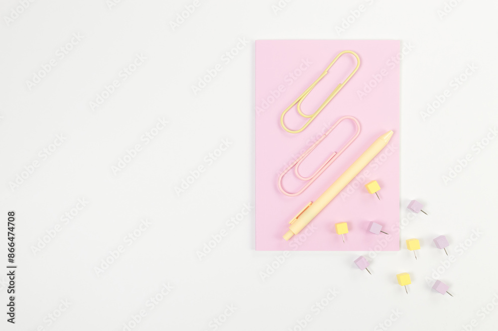 Top view of pink notebook on white background. Paperclips, pen and pins. School, office wallpaper. Flat lay, copy space. Top view of pink notebook on white background. Paperclips, pen and pins. School, office wallpaper. Flat lay, copy space.