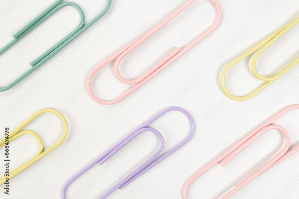 Top view of colorful paperclips on white background. School, office wallpaper. Flat lay, copy space. Top view of colorful paperclips on white background. School, office wallpaper. Flat lay, copy space.