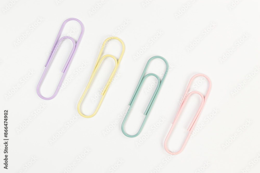Top view of colorful paperclips on white background. School, office wallpaper. Flat lay, copy space. Top view of colorful paperclips on white background. School, office wallpaper. Flat lay, copy space.