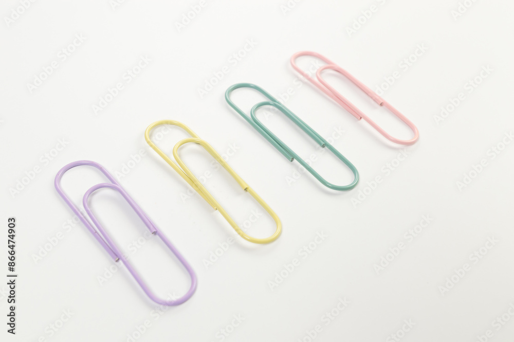 Top view of colorful paperclips on white background. School, office wallpaper. Flat lay, copy space. Top view of colorful paperclips on white background. School, office wallpaper. Flat lay, copy space.