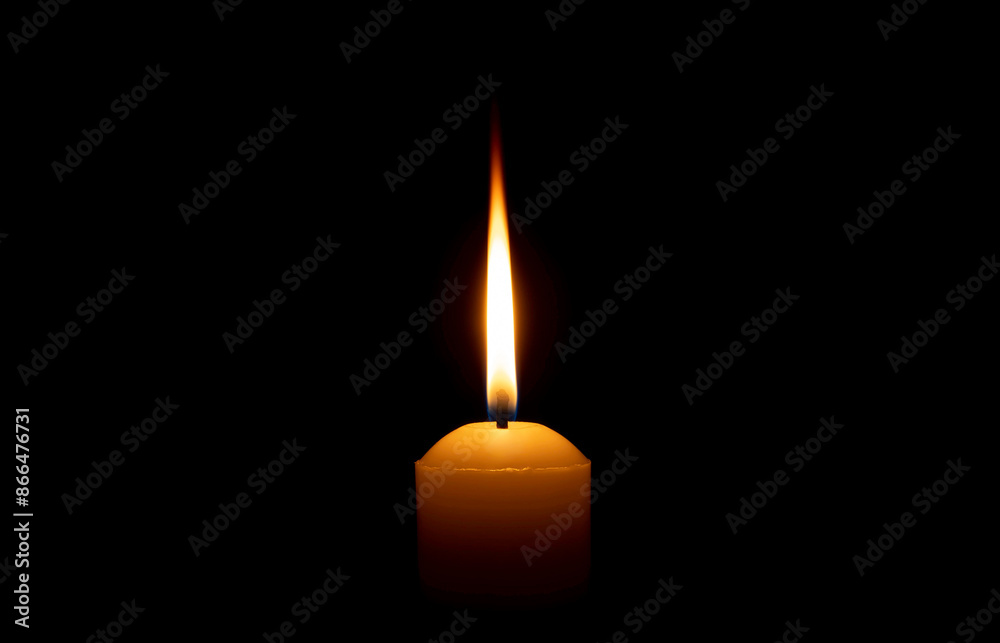 Single burning candle flame or light glowing on a big white candle on black or dark background on table in church for Christmas, funeral or memorial service with copy space. Single burning candle flame or light glowing on a big white candle on black or dark background on table in church for Christmas, funeral or memorial service with copy space.