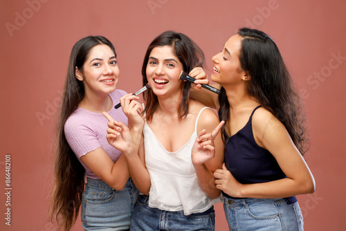 Two Casual Women Trying To Applying Makeup To Their Friends Face