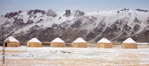 Yurts in winter. National ancient house of the peoples of Kyrgyzstan and Asian countries. national housing. Yurts against the backdrop of snow and highlands. Yurt camp for tourists. photo