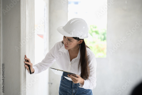 Female civil engineer with inspection check sheet consult with construction site foreman technician for inspect building condition defect pointing wall crack wait for repair.