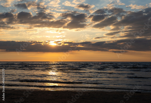 A beautiful sunrise over the Baltic sea - horizon and colorful sky. Natural summer scenery at the Baltic beach in Latvia, Northern Europe.