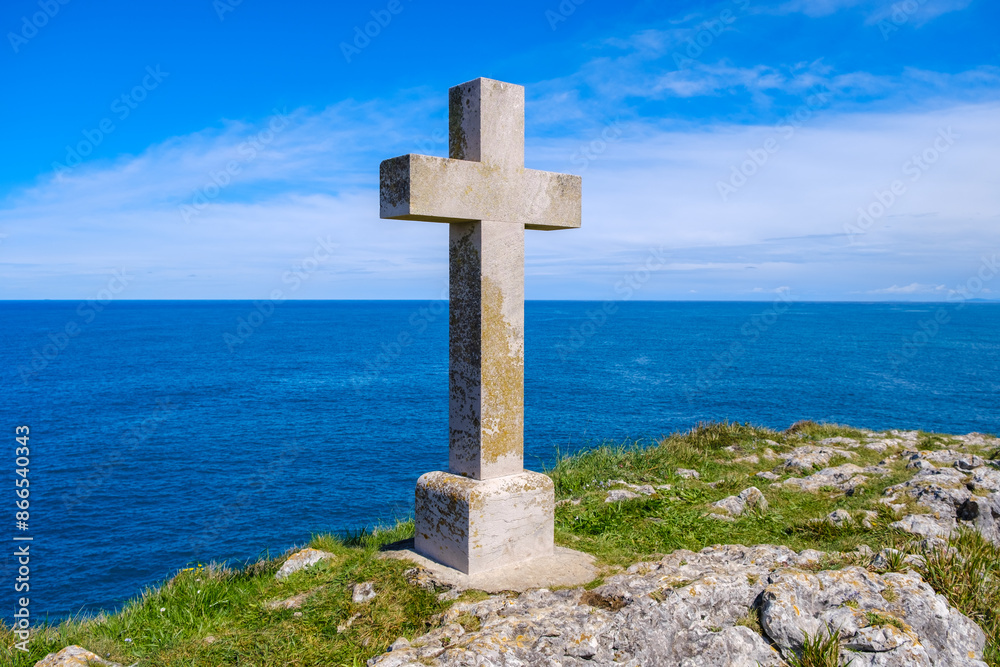 A Christian cross stands tall on a hill, with the vast expanse of the ocean in the background. The scene captures the cross as it overlooks the sea, symbolizing faith and spirituality. A Christian cross stands tall on a hill, with the vast expanse of the ocean in the background. The scene captures the cross as it overlooks the sea, symbolizing faith and spirituality.