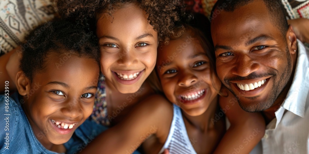 Fototapeta premium A family of four, two boys and two girls, are smiling and hugging each other