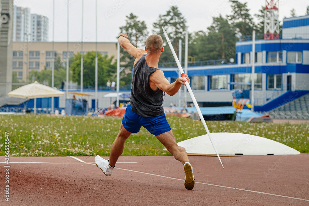 Fototapeta premium male athlete javelin throw rear view at summer athletics games