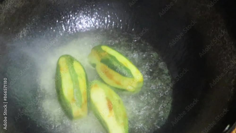 Close-up video of pointed gourd, parwal/parval (patol) frying in pan.4k. Pointed gourd potato curry, Indian food.