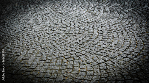Old tiled pavement background. Circle cobblestone paving texture. Vignette frame  effect.