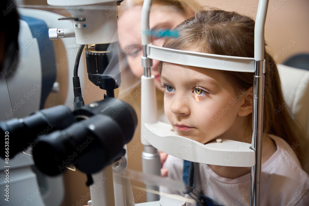 Ophthalmologist uses special equipment to check vision of young patient