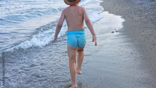kid playing on beach in sea water swimming,splashing,running or floating on waves.child with sun cap or diving snorkel mask.preschooler boy playing with boat ship toy,digging with plastic shovel.