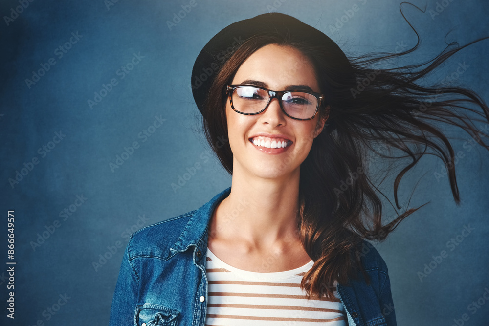 Girl, portrait and wind in studio with glasses for eyecare, optometry and prescription for clear vision with happiness. Woman, spectacles and isolated on dark background for eyewear and eyesight. Girl, portrait and wind in studio with glasses for eyecare, optometry and prescription for clear vision with happiness. Woman, spectacles and isolated on dark background for eyewear and eyesight.