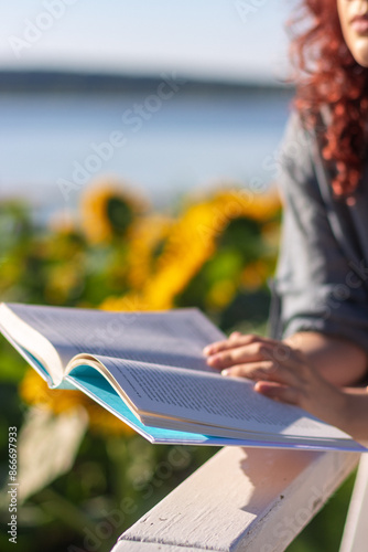 A book in the hands of a woman. Reading in nature