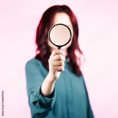 Portrait of a woman. Looking through a magnifying glass.