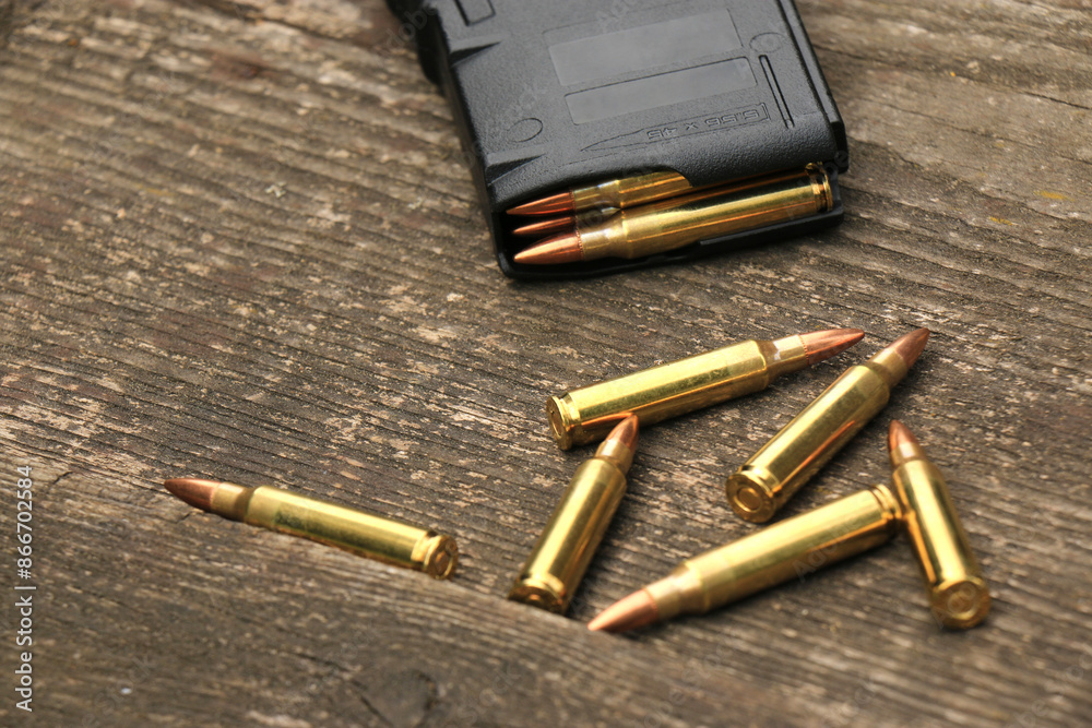 A loaded AR15 rifle magazine and ammunition on the background of old boards A loaded AR15 rifle magazine and ammunition on the background of old boards