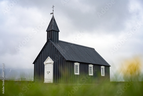 Obraz na płótnie Stunning view of the black church of Budir with defocused grass in the foreground. Búðakirkja is a small wooden church located on the south side of Snæfellsnes, Iceland.. w salonie