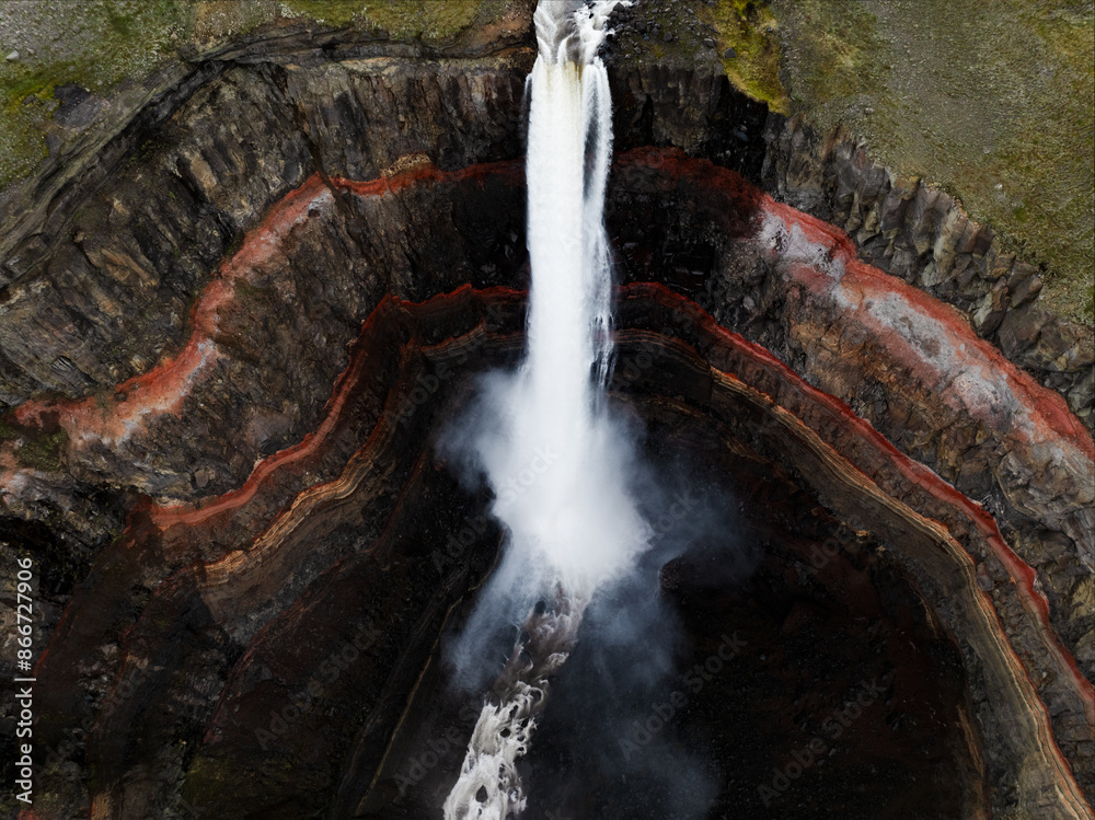 View from above, stunning aerial view of the Hengifoss Waterfall. Hengifoss, is eye-catching due to the striking red clay and black basalt patterns of the cliff face. Fljótsdalshreppur, East Iceland.