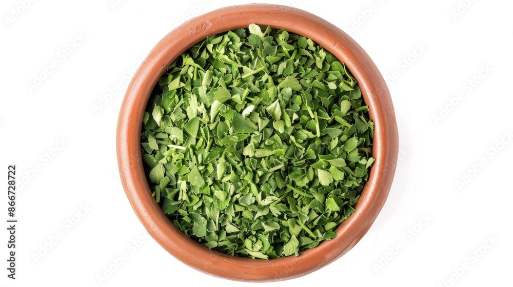 A bowl filled with green leaves on a white background A bowl filled with green leaves on a white background