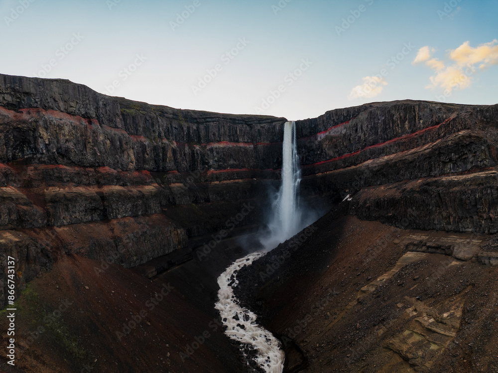View from above, stunning aerial view of the Hengifoss Waterfall. Hengifoss, is eye-catching due to the striking red clay and black basalt patterns of the cliff face. Fljótsdalshreppur, East Iceland.
