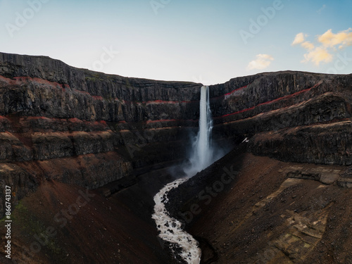 Obraz na płótnie View from above, stunning aerial view of the Hengifoss Waterfall. Hengifoss, is eye-catching due to the striking red clay and black basalt patterns of the cliff face. Fljótsdalshreppur, East Iceland. w salonie