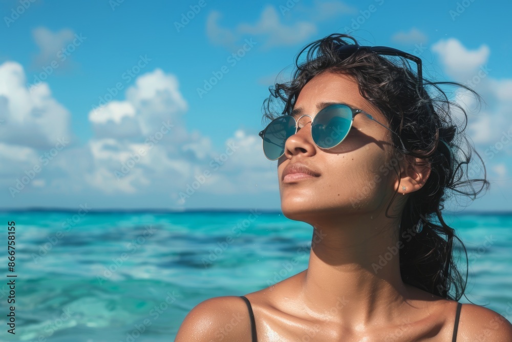 Portrait of a content indian woman in her 20s wearing a trendy sunglasses isolated in stunning ocean reef Portrait of a content indian woman in her 20s wearing a trendy sunglasses isolated in stunning ocean reef