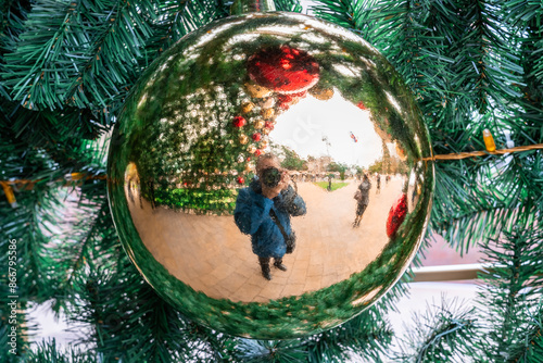 the photographer takes pictures of himself through a Christmas toy