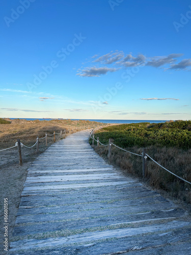 road made of wooden planks leading to the sea on a sunny day in Spain, path to the sea