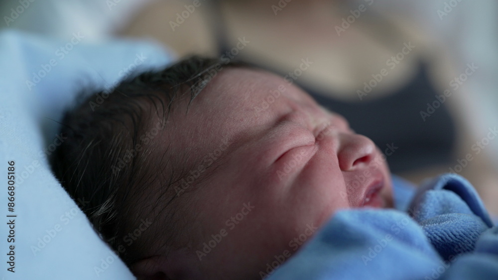 Close-up of newborn baby crying, wrapped in blue blanket, capturing raw emotion and the first expressions of life, ideal for themes of infancy, vulnerability, and the beauty of new beginnings Close-up of newborn baby crying, wrapped in blue blanket, capturing raw emotion and the first expressions of life, ideal for themes of infancy, vulnerability, and the beauty of new beginnings