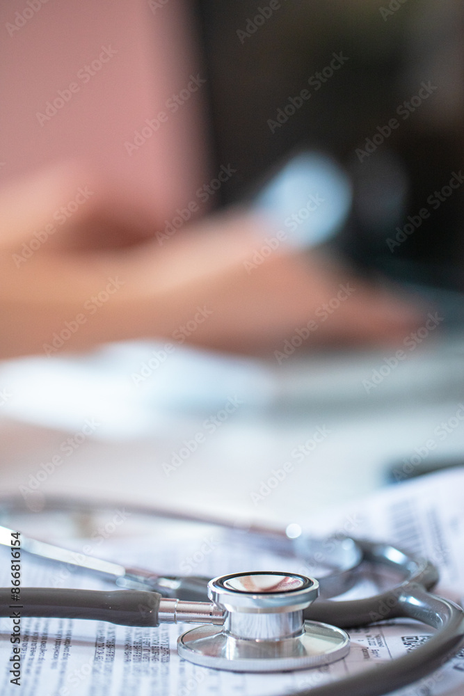 Stethoscope on doctor's prescription on background of specialist's hands working on laptop. Vertical photo Stethoscope on doctor's prescription on background of specialist's hands working on laptop. Vertical photo