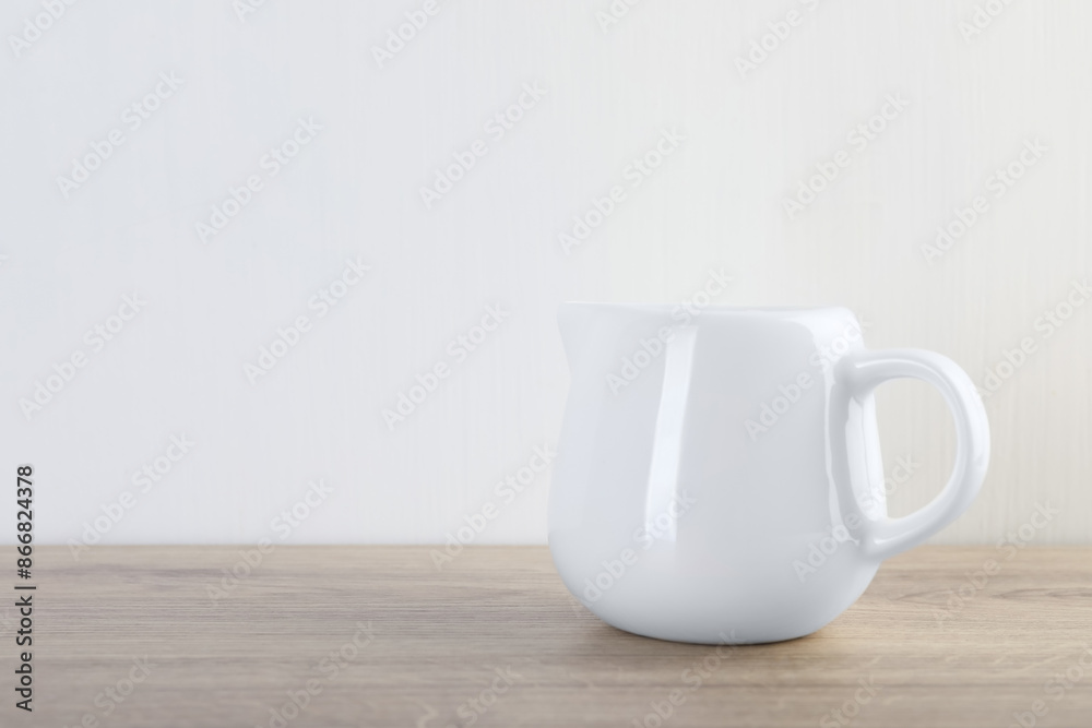 Jug of fresh milk on wooden table, space for text Jug of fresh milk on wooden table, space for text