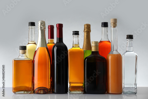 Wallpaper Mural Bottles of different alcoholic drinks on white table against light background Torontodigital.ca