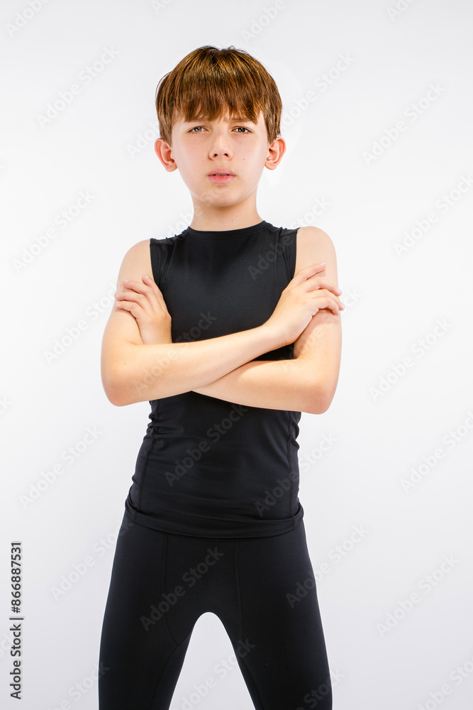 Young teen boy track runner in black running tights standing with arms crossed, staring straight ahead with an intimidating game face expression Young teen boy track runner in black running tights standing with arms crossed, staring straight ahead with an intimidating game face expression