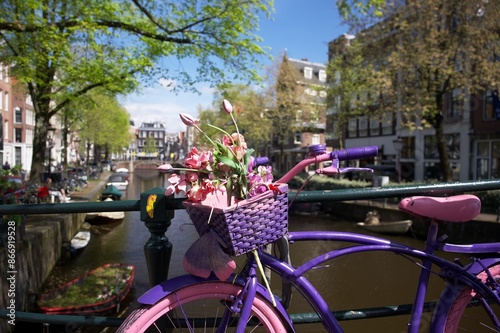 Photography Pink bicycle with flowers on a bridge near a canal in Amsterdam
