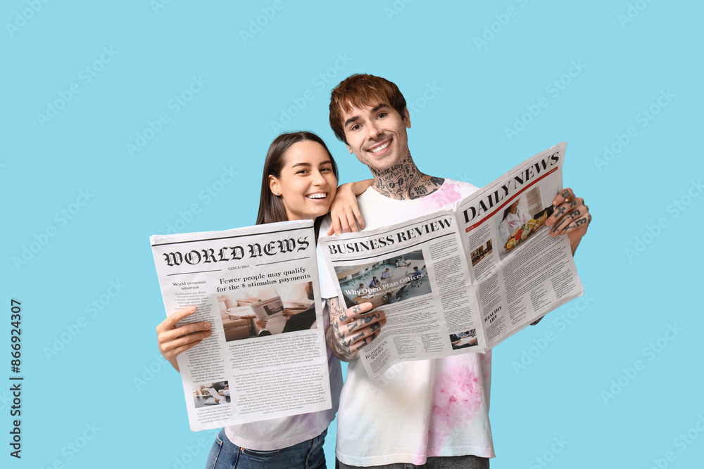 © Pixel-Shot - Young couple with newspapers on blue background © Pixel-Shot - Young couple with newspapers on blue background