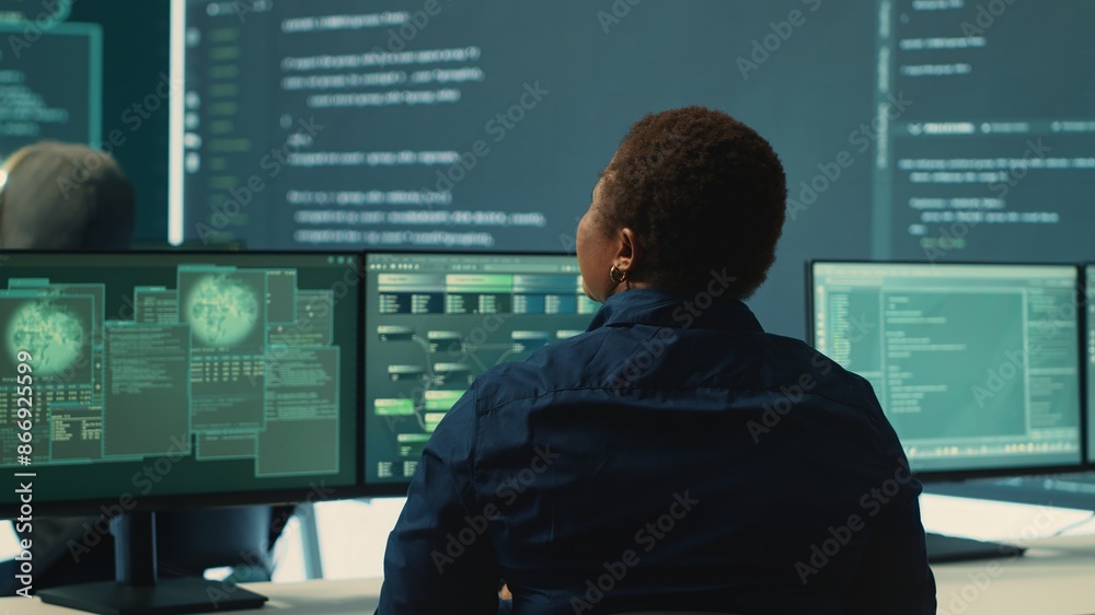 Governmental hackers analyzing big data for cyber threat detection, working at agency desks. Professional expert woman analyzes cyber intelligence and prevention of digital threats. Camera A.