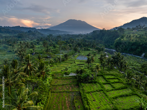 Aerial image of dramatic sunrise with orange clouds over rice fields in Sidemen, Bali, Indonesia
