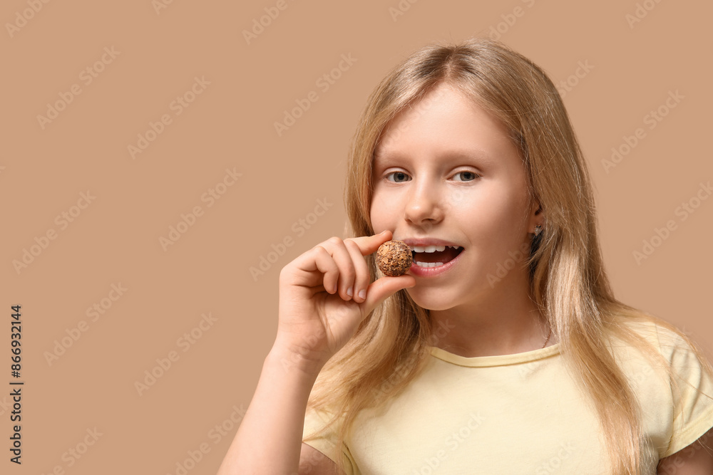 Cute little girl with sweet chocolate candy on brown background Cute little girl with sweet chocolate candy on brown background