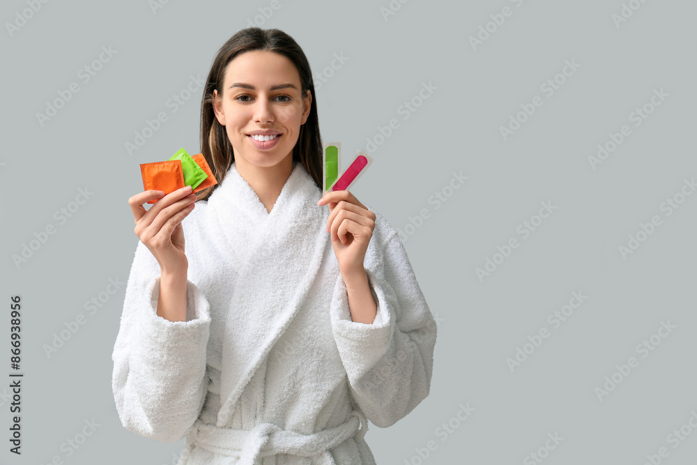 Beautiful young woman with different means of contraception on grey background Beautiful young woman with different means of contraception on grey background