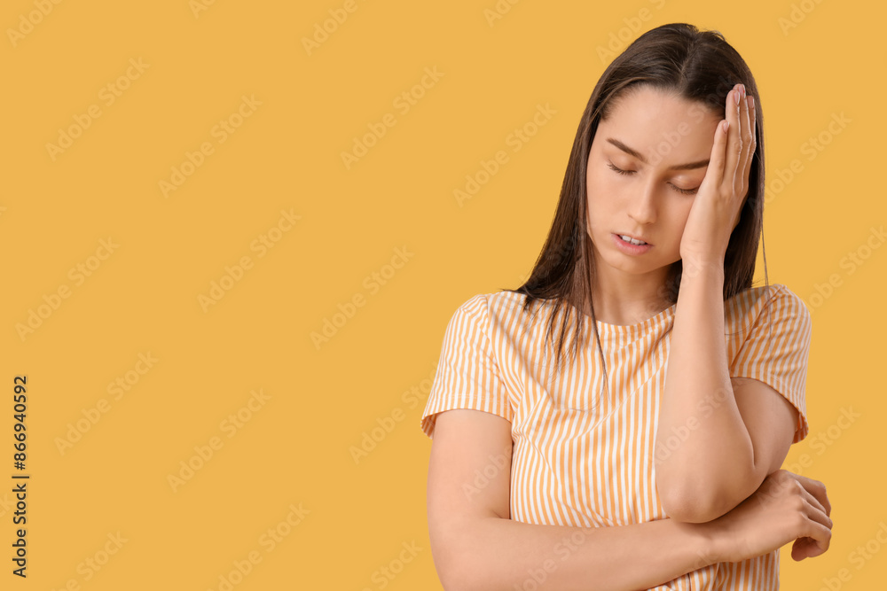 Tired young woman suffering from headache on yellow background Tired young woman suffering from headache on yellow background
